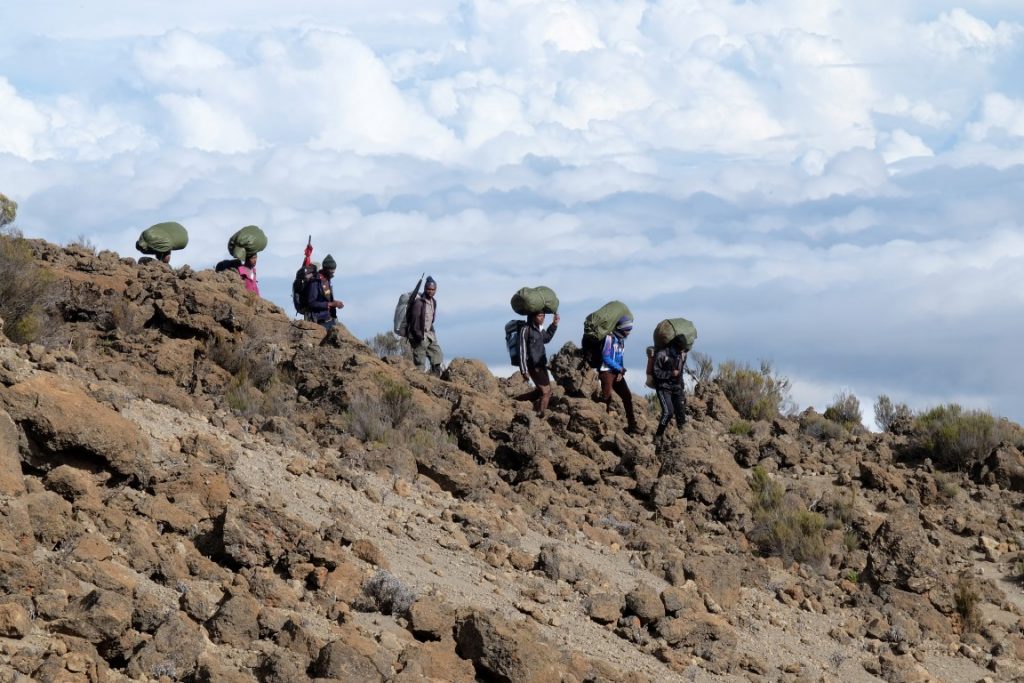porters walking in a line on kilimanjaro